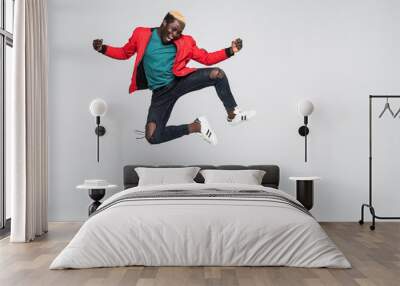 full length portrait of a cheerful afro american man jumping isolated on a white background Wall mural